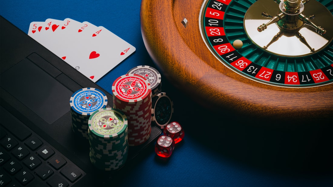 Roulette dan tumpukan chip kasino di meja permainan